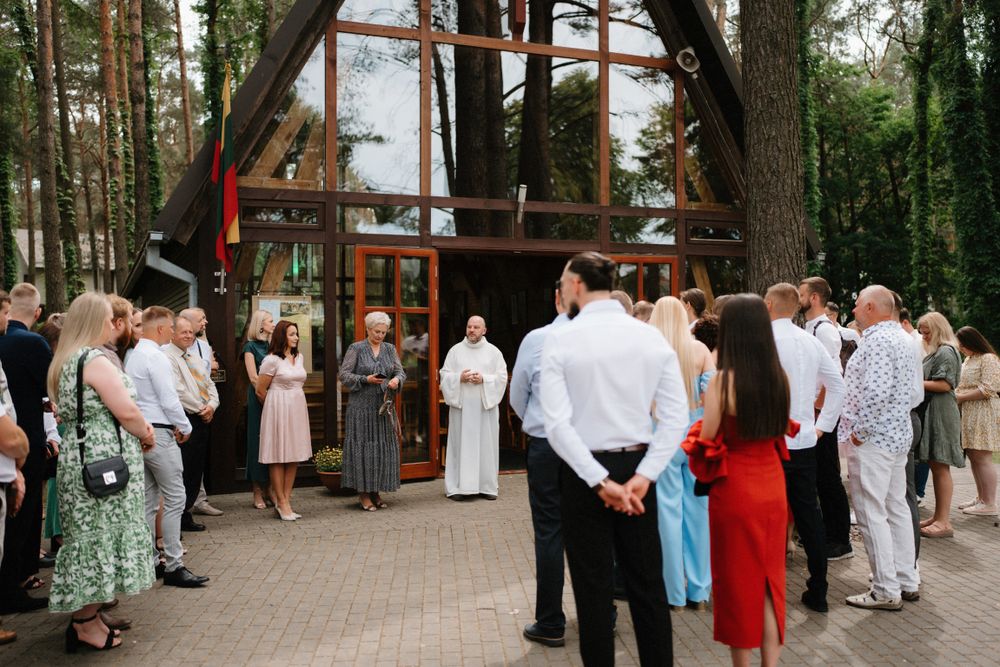 Outdoor wedding reception with guests mingling under string lights.