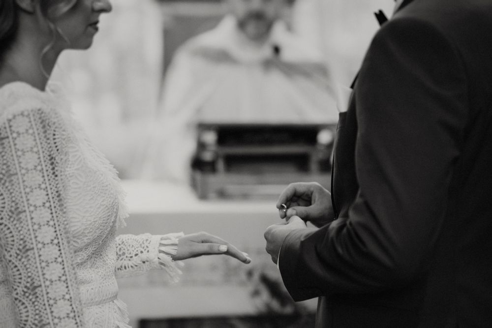Close-up of wedding ring exchange between couple during ceremony.