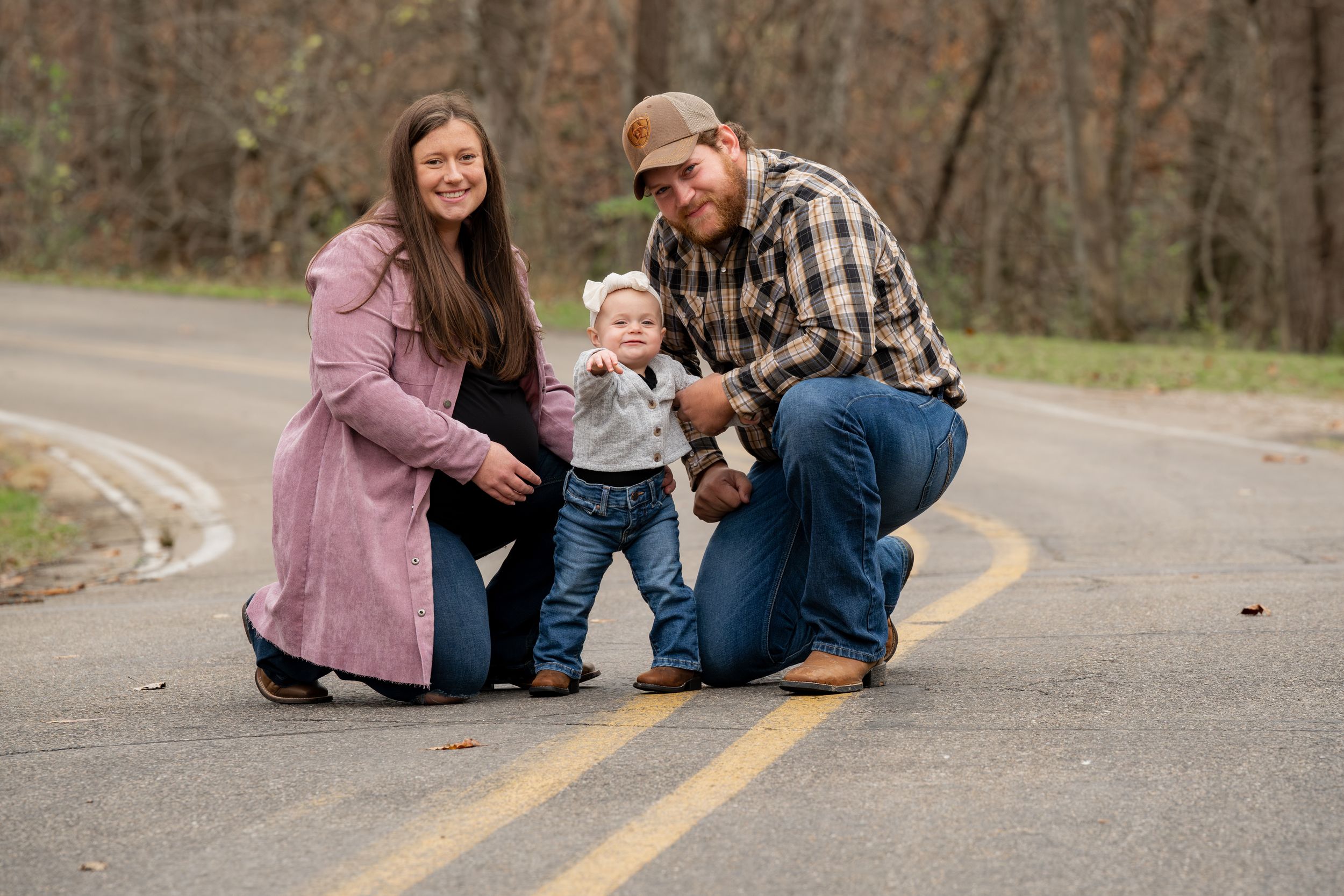 Family sharing a playful moment together on a paved road.