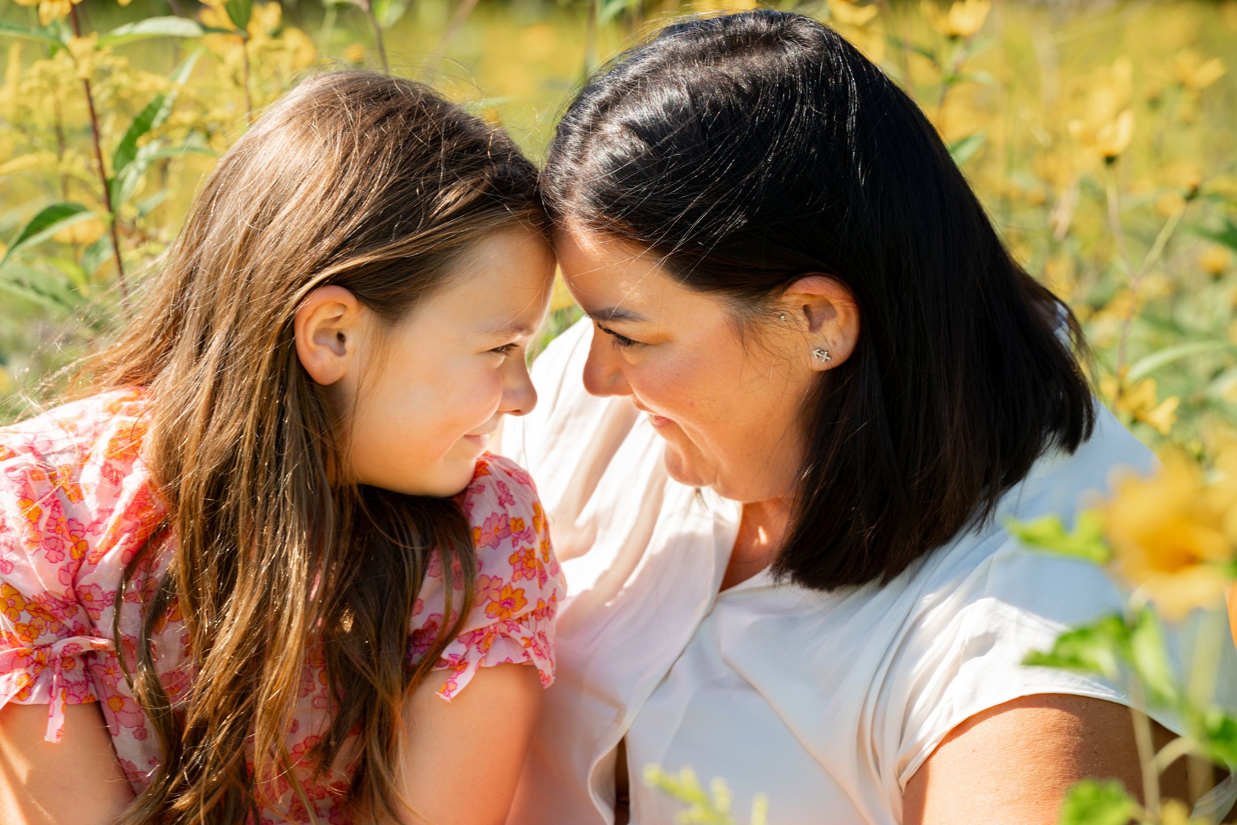 An intimate moment of connection in a field of yellow summer flowers.