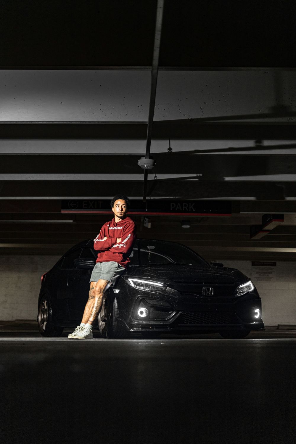 A sleek black Honda Civic parked in a dark parking garage with dramatic lighting.