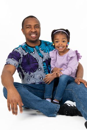 Portrait featuring matching blue and purple patterned outfits against white background.