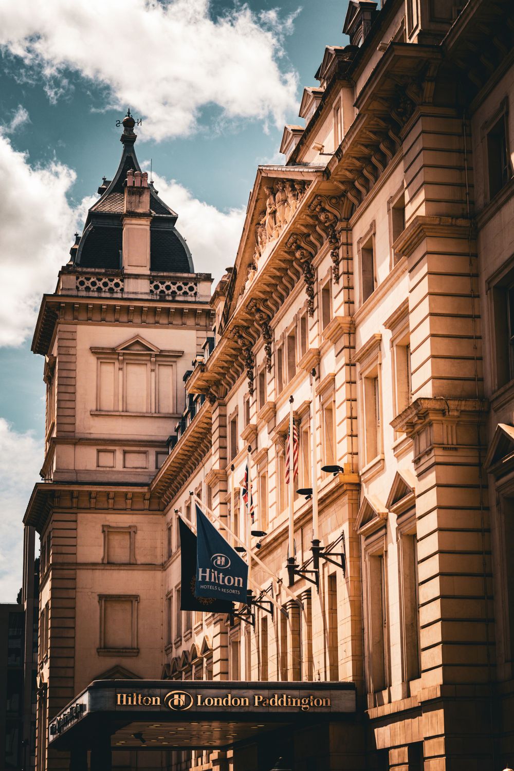 The elegant facade of the Hilton London Paddington hotel with classical architecture.