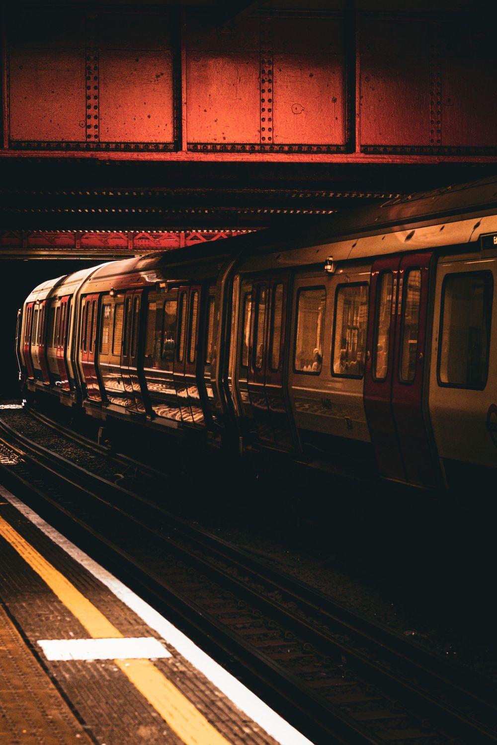 Dark subway platform with illuminated train cars creating moody urban atmosphere.