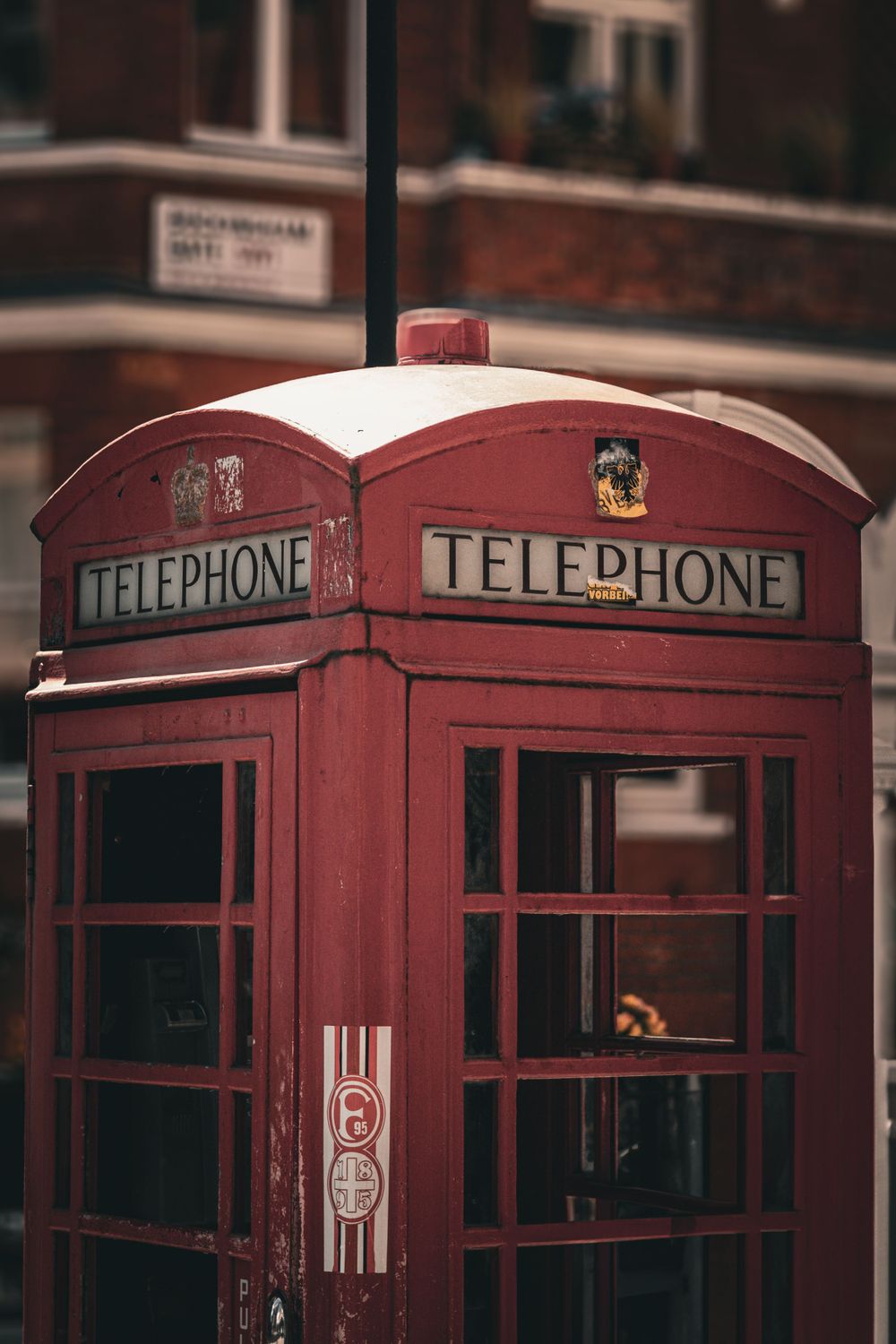 Row of iconic red British telephone booths lined up on a London street.