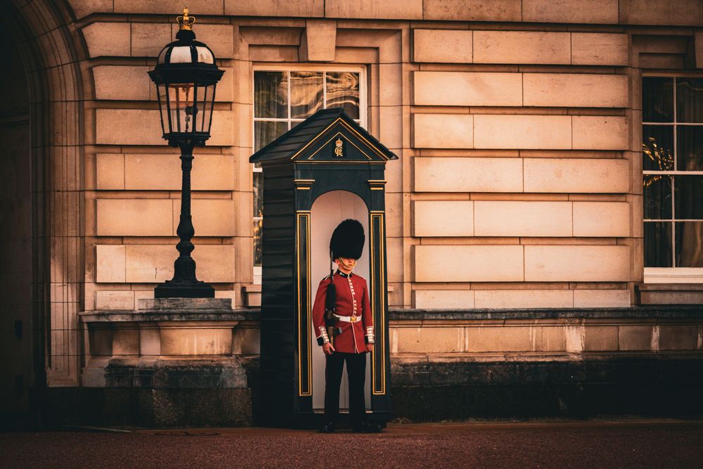 Traditional British royal guard sentry boxes outside historic palace building.