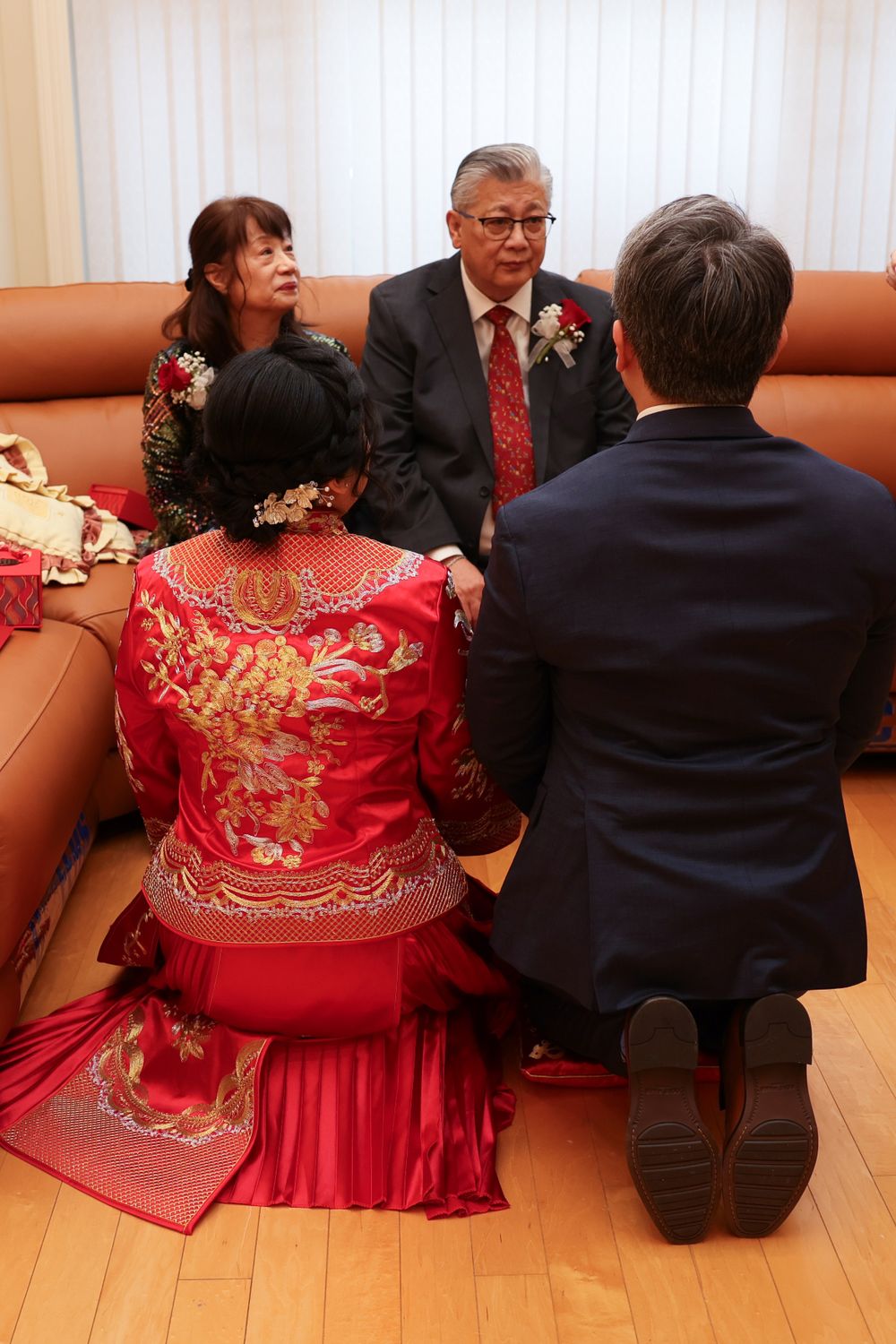 A traditional chinese tea and wedding ceremony featuring a couple in traditional Chinese red dress with mother and father.