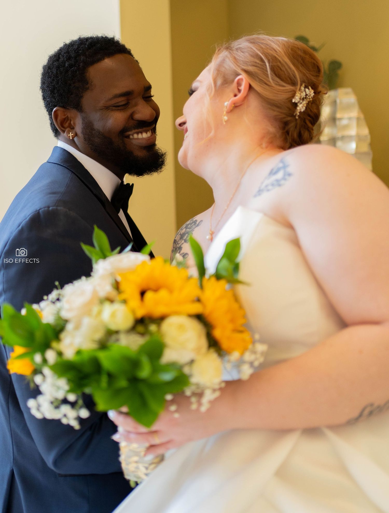 Beautiful newlywed couple in formal attire smile for their wedding portrait by a pool.