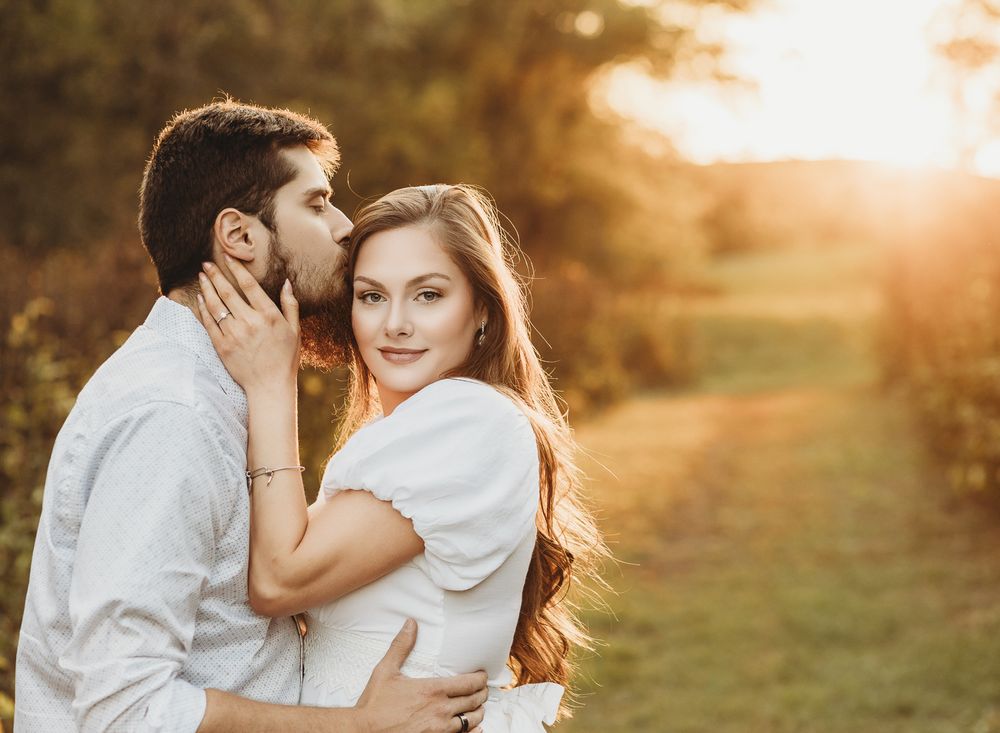Romantic couple embracing in warm sunset light amidst natural outdoor setting. Pittsburgh engagement photographer