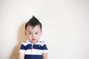 Toddler boy sporting a mohawk and striped polo shirt, taken by Phoebe Lee Photo in a Toronto indoor portrait session