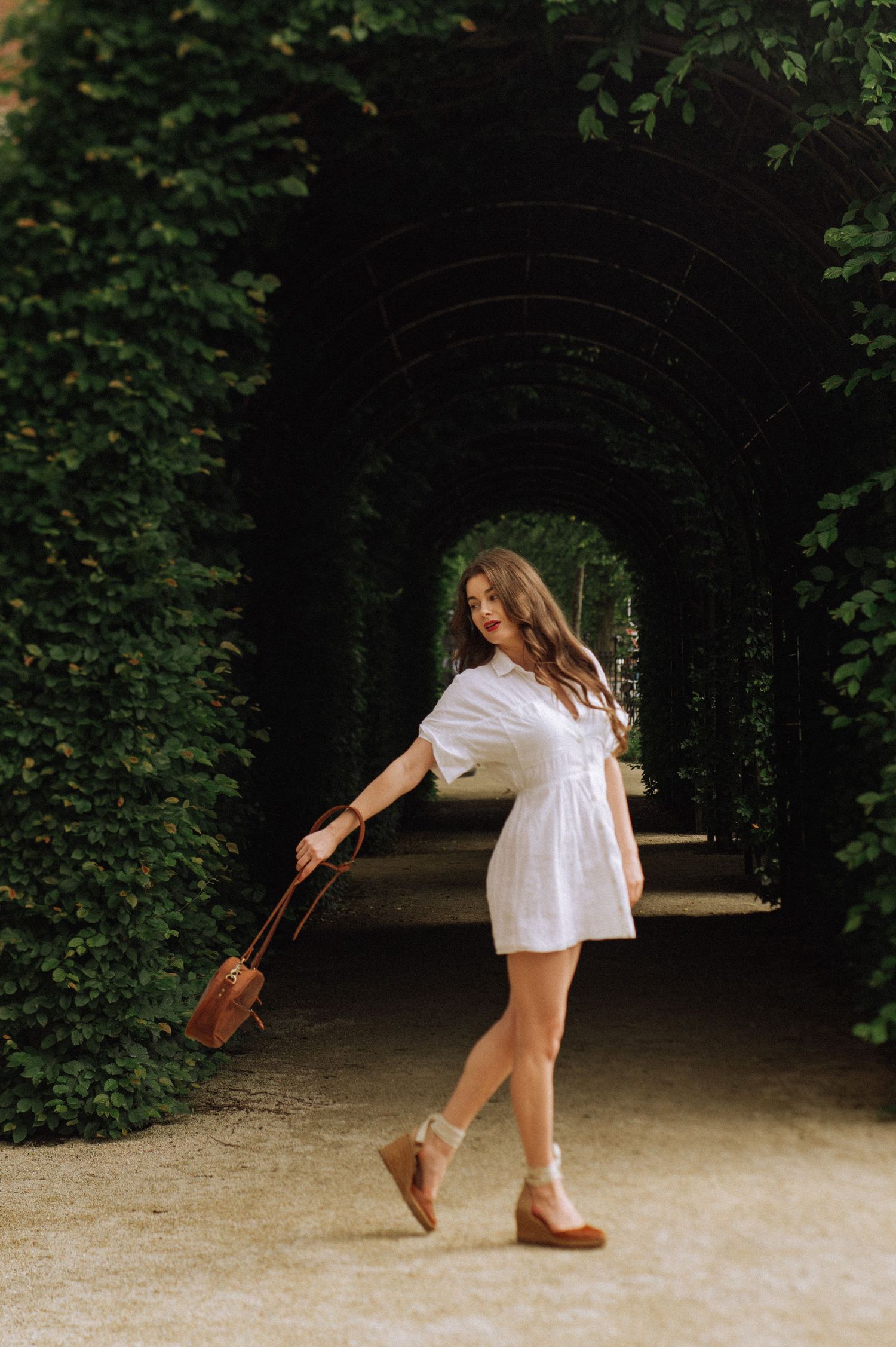 Individual portrait of a woman in a white dress in the Rijksmuseum garden, Amsterdam.