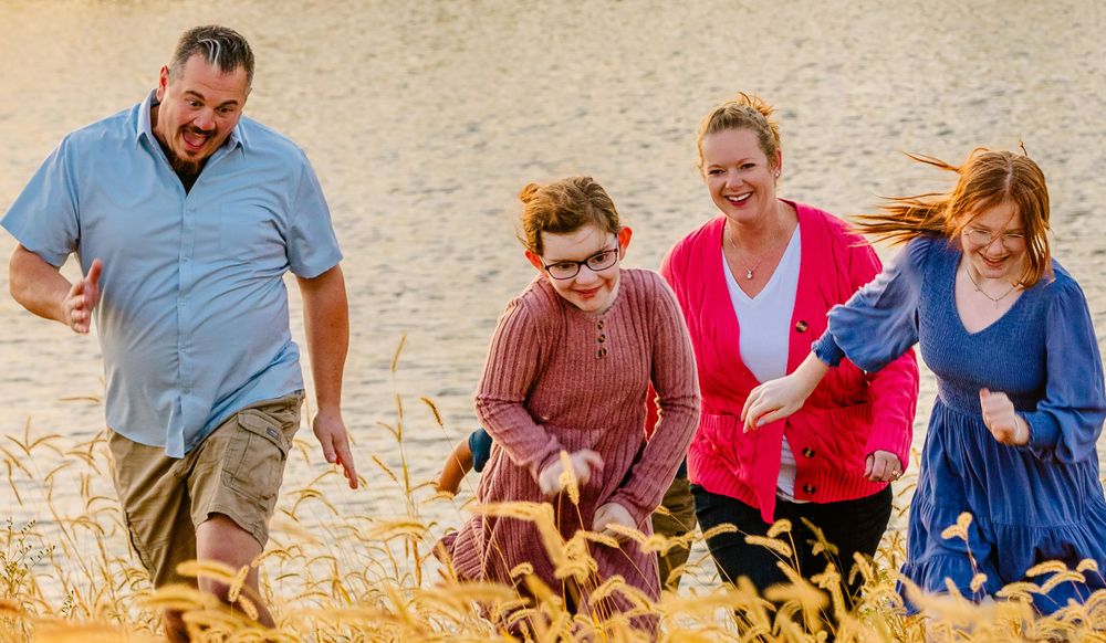 A group walks together through a golden wheat field on a sunny day, enjoying the outdoors together.