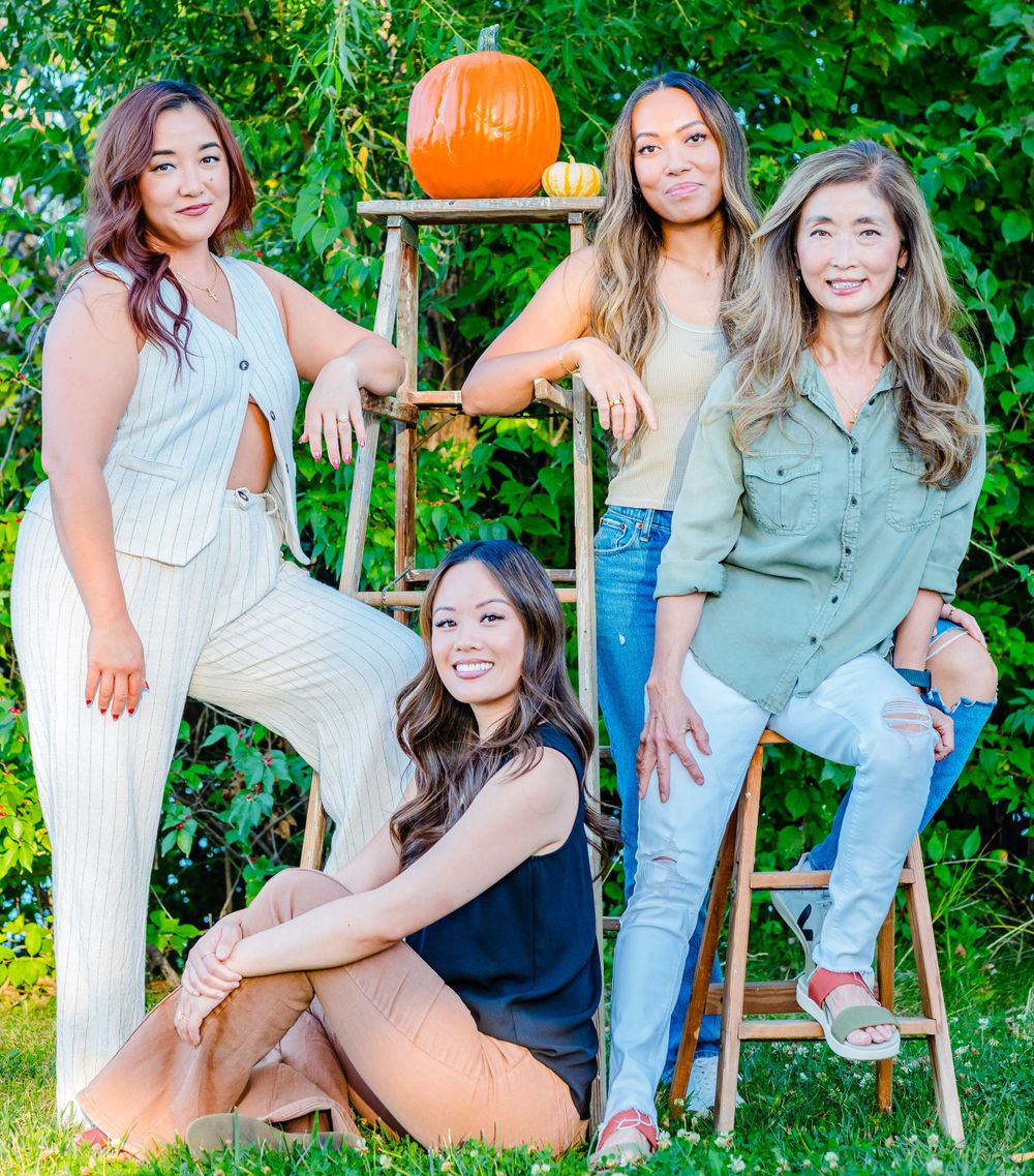 Fall portrait with a decorative pumpkin on ladder outdoors surrounded by green foliage.