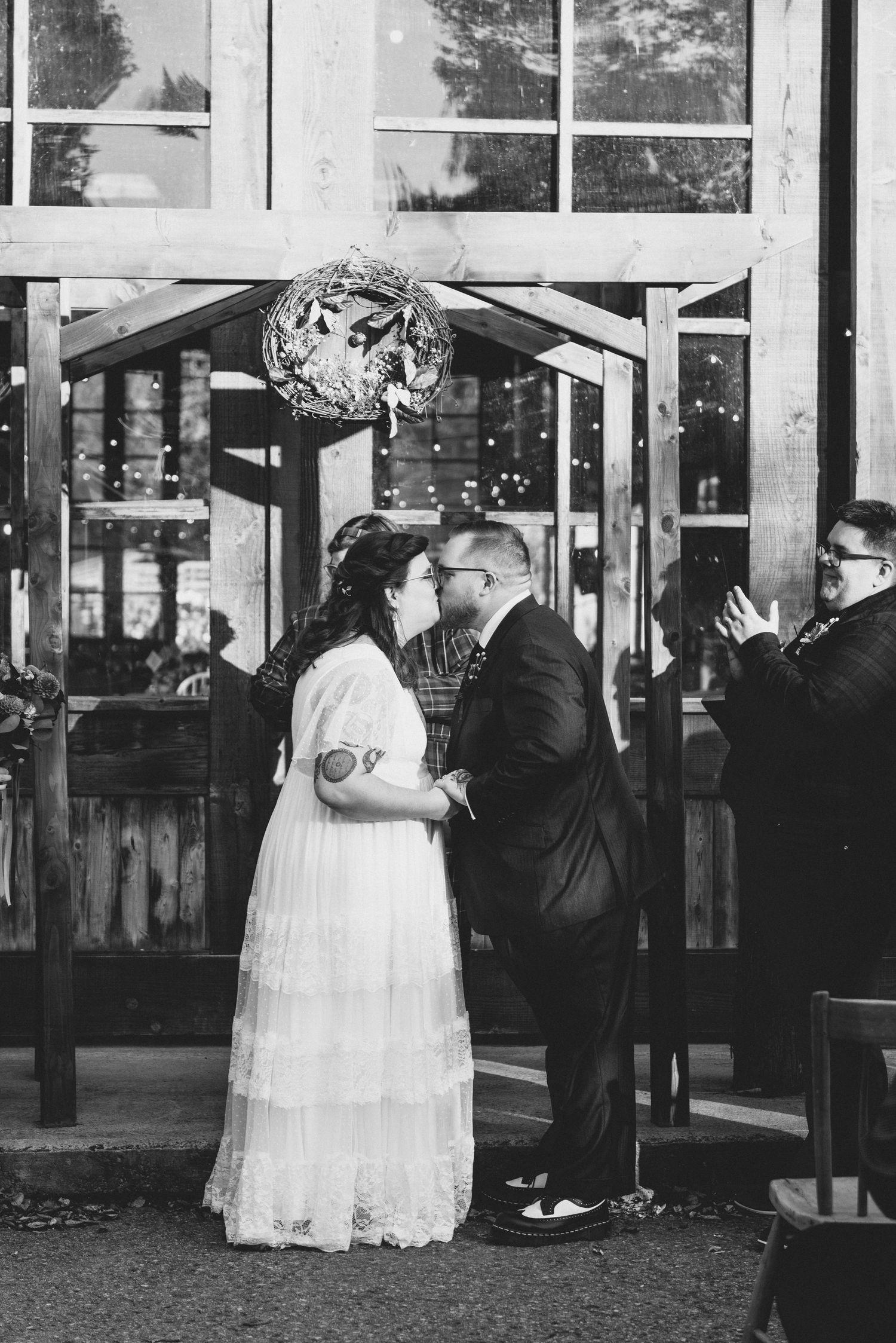 A romantic outdoor wedding moment under a glittering disco ball with a bride in a white lace dress and groom in a dark suit.