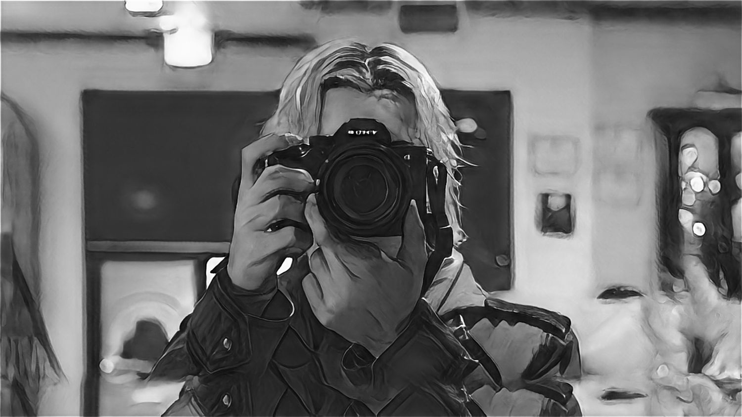 A monochrome photo of someone holding up a camera to take a self-portrait reflection shot.