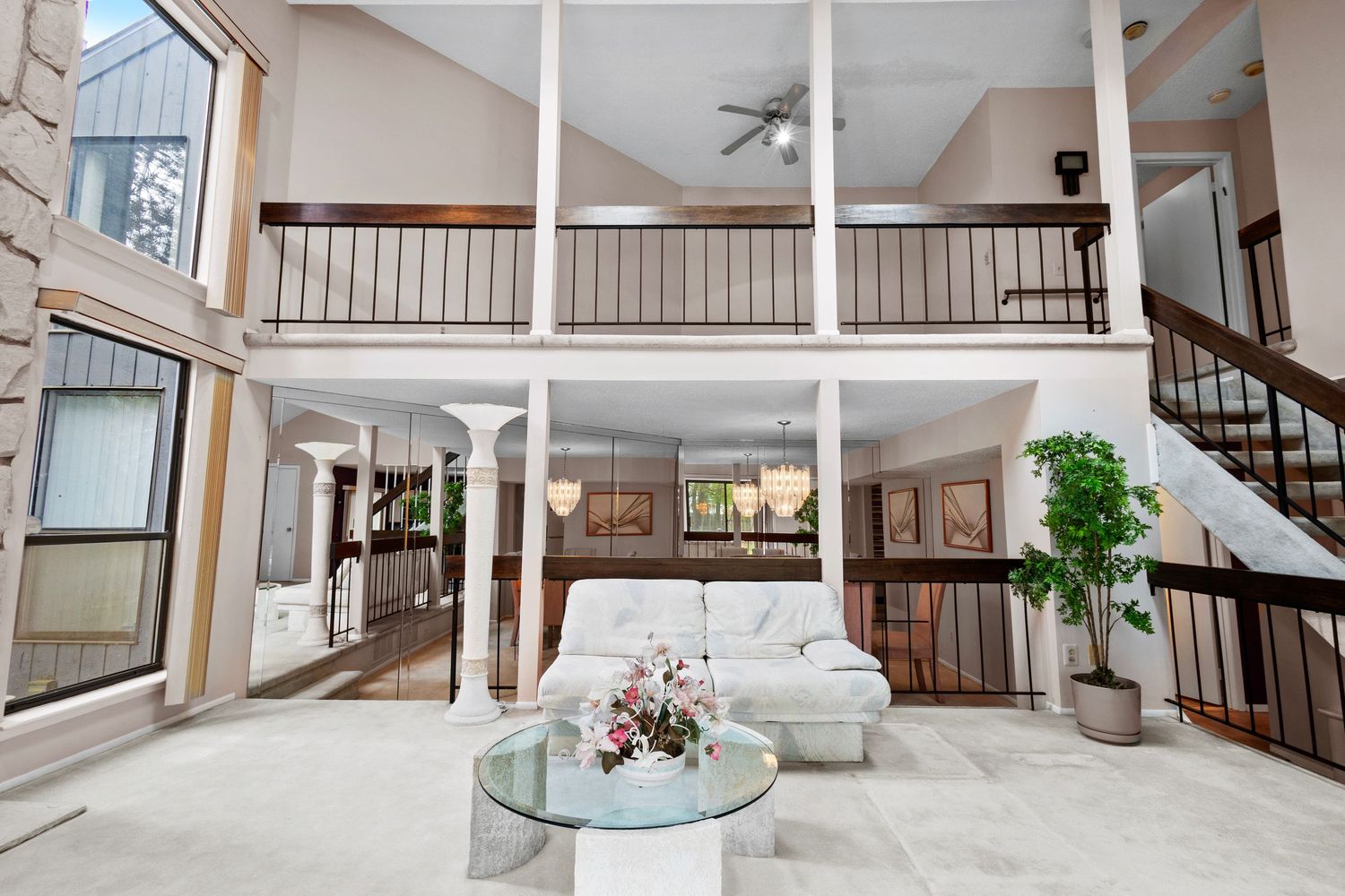 Open concept living area with wood railings, hardwood floors, and modern finishes showcases bright natural lighting.