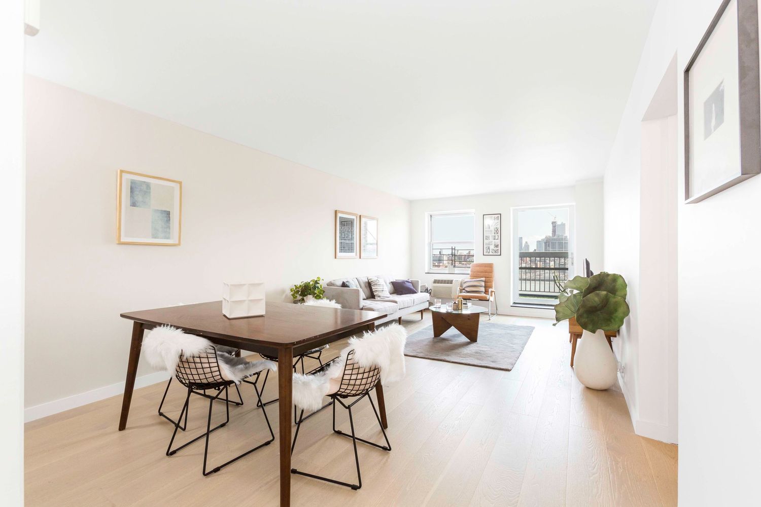 Bright open concept living and dining area with modern furniture and hardwood floors.