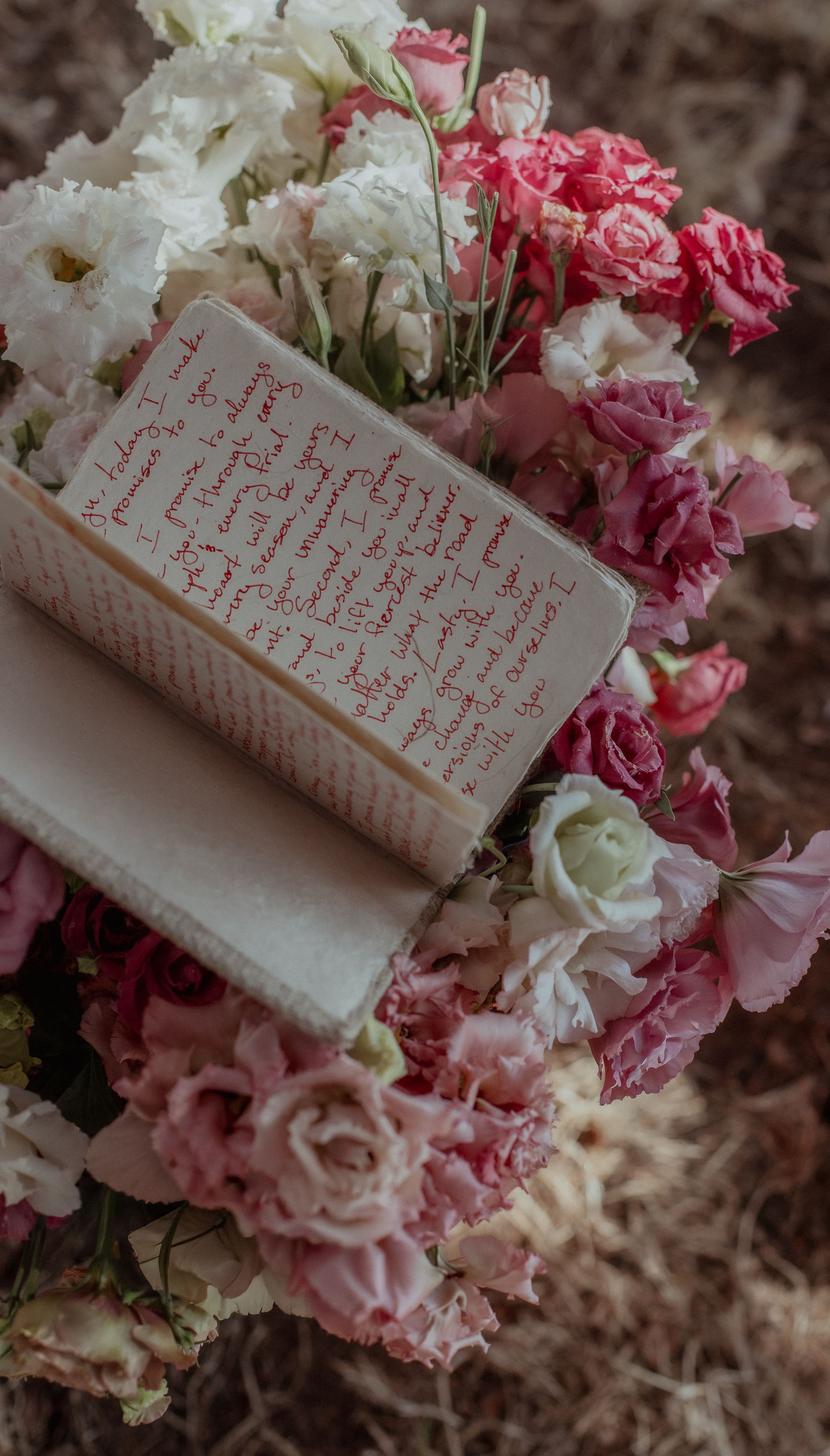 A vintage book page surrounded by delicate pink and white roses in a romantic arrangement.