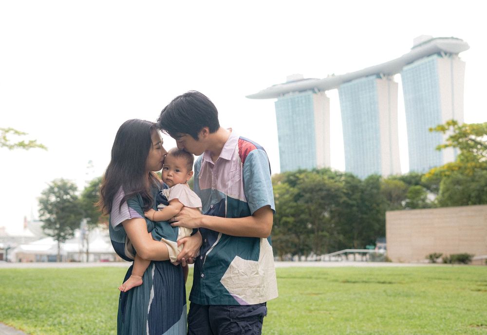 A family shares a tender moment with their baby in front of Marina Bay Sands in Singapore.