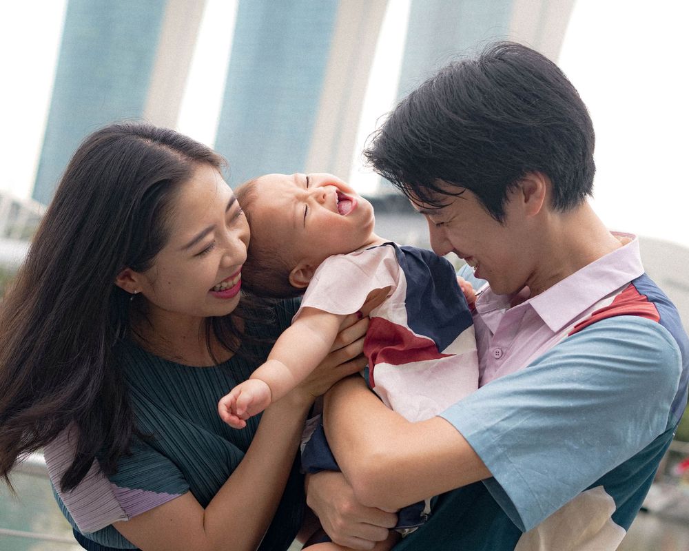 Parents share laughs with their baby at Marina Bay waterfront in Singapore.