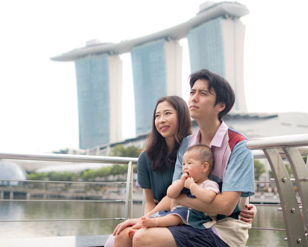 A family enjoys scenic views at Marina Bay Sands Singapore with the iconic hotel towers in the background.