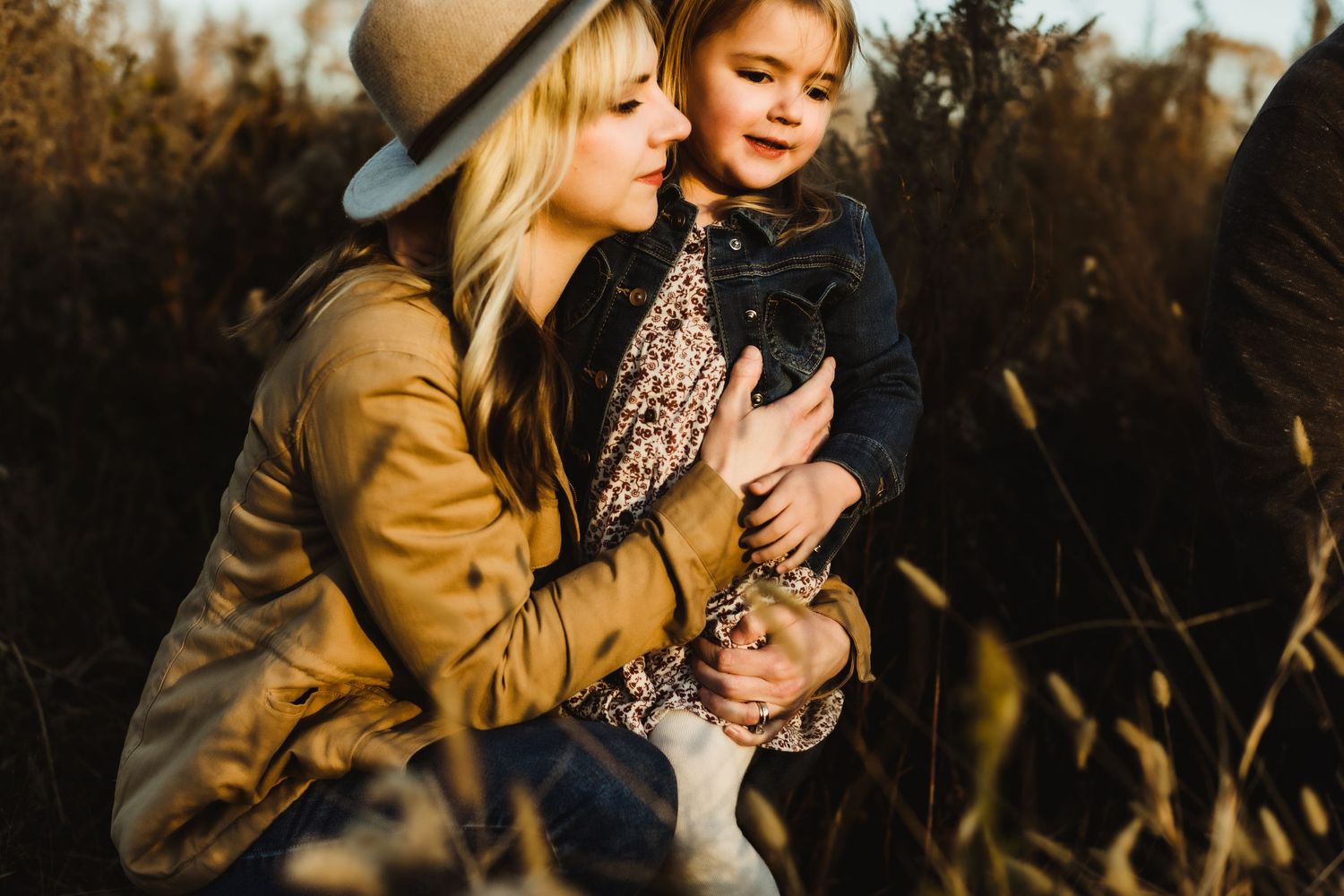 A tender moment shared between two people in a golden field during sunset with warm autumn light.