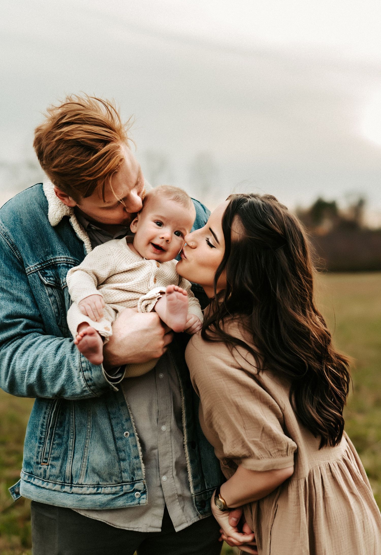 Happy family sharing a tender moment together outdoors in a field during golden hour.