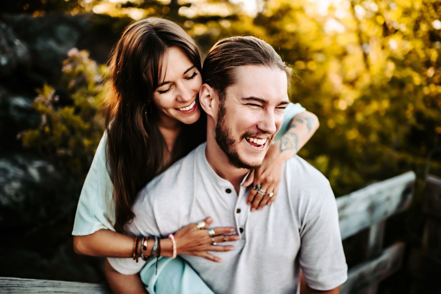 A happy couple shares a joyful moment together outdoors during golden hour sunset.