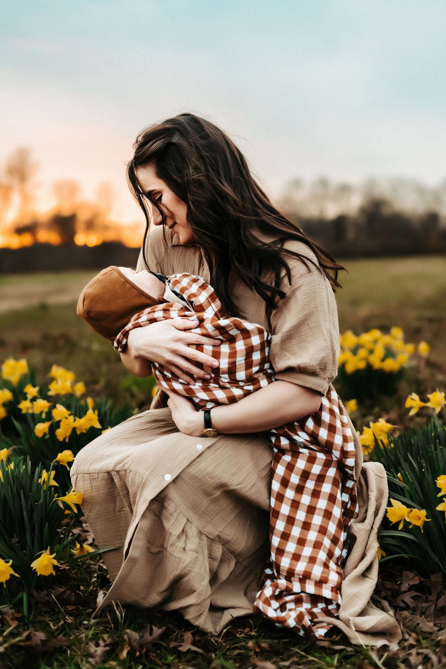 A tender moment captured in a field of daffodils at sunset with warm lighting and spring flowers blooming.