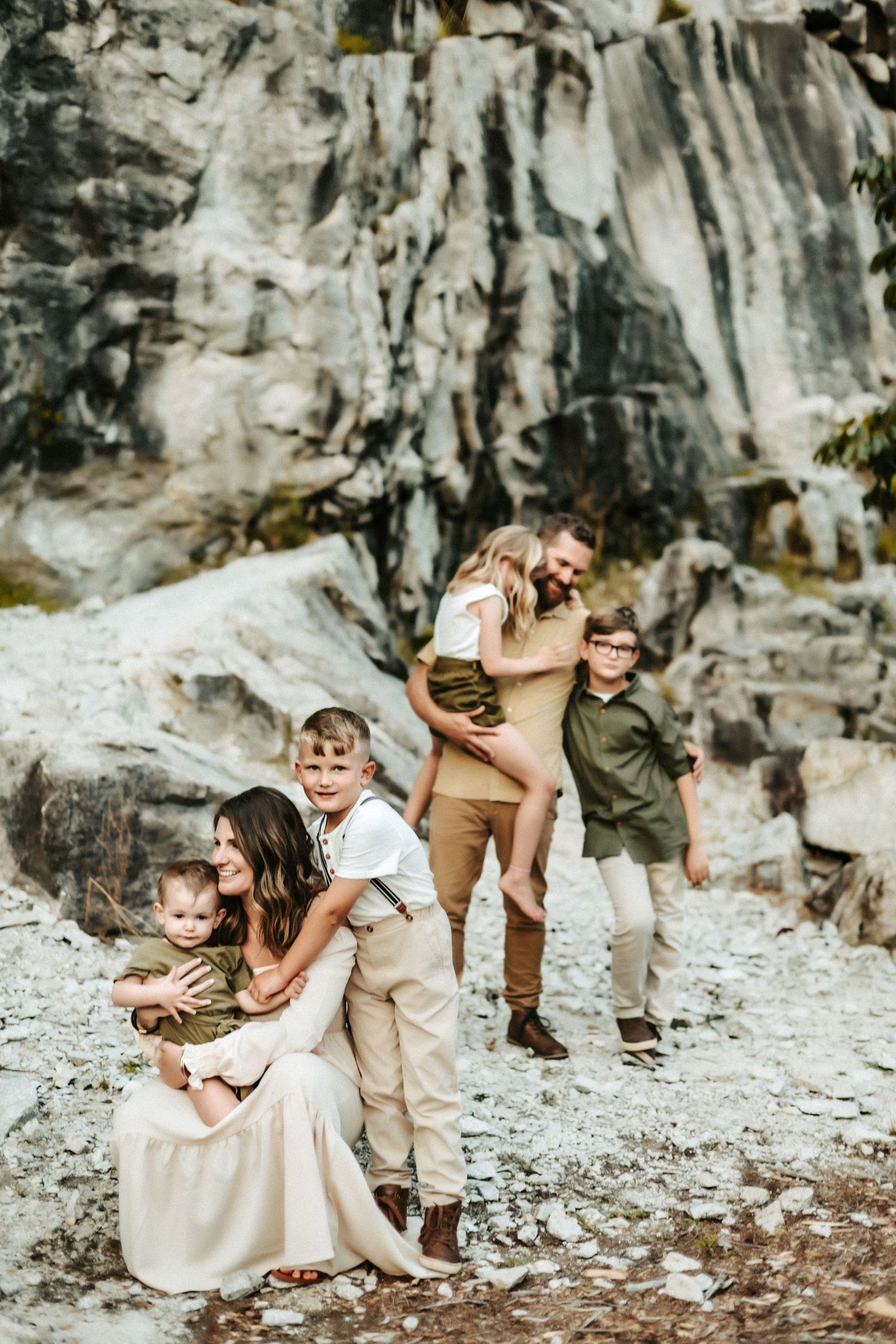 A tender moment captured of a group embracing and laughing together on a rocky mountain trail.