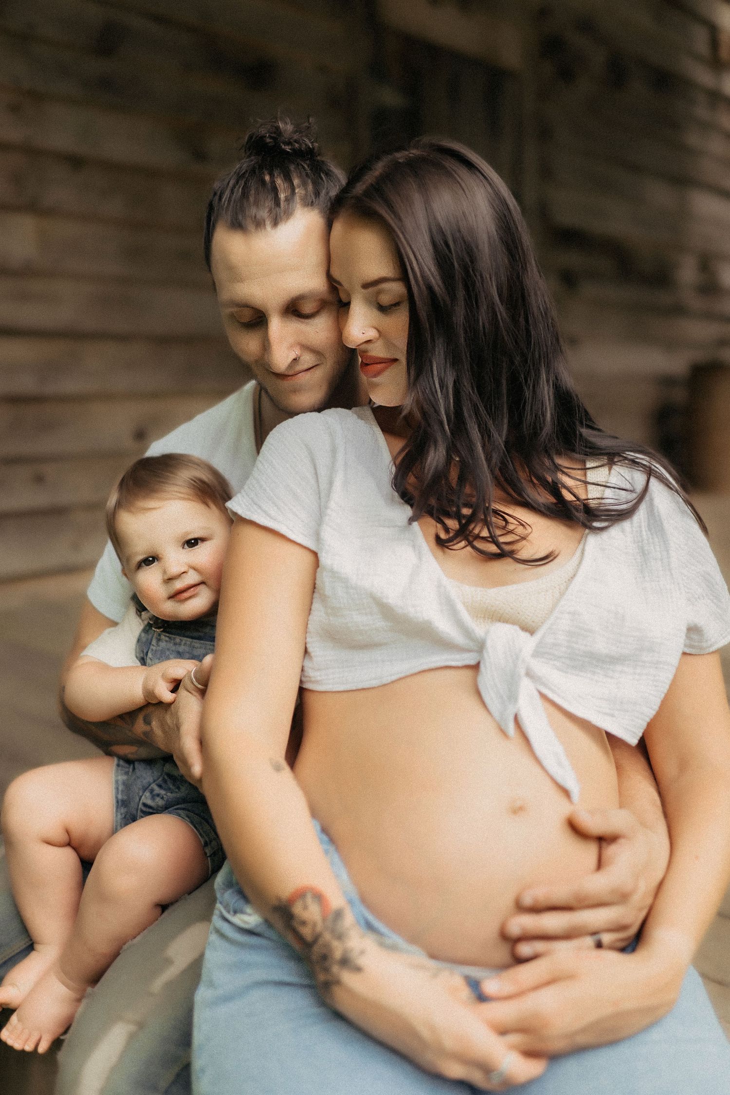 A tender family portrait shows an intimate moment as they await their new arrival, sharing warmth and love together.