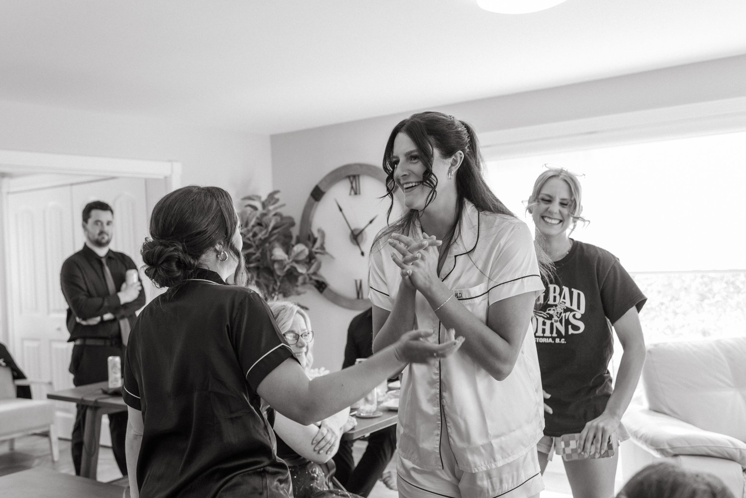 People gathered together in a casual indoor setting, sharing a joyful moment in black and white photography.