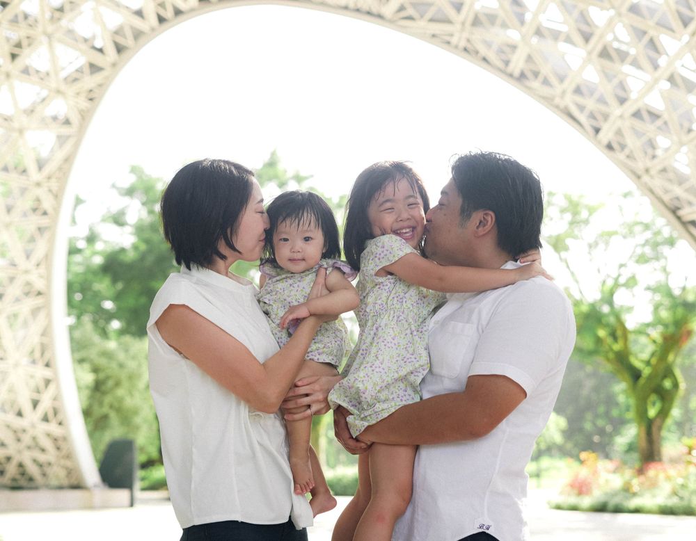 Family sharing joyful moment together under decorative garden archway.