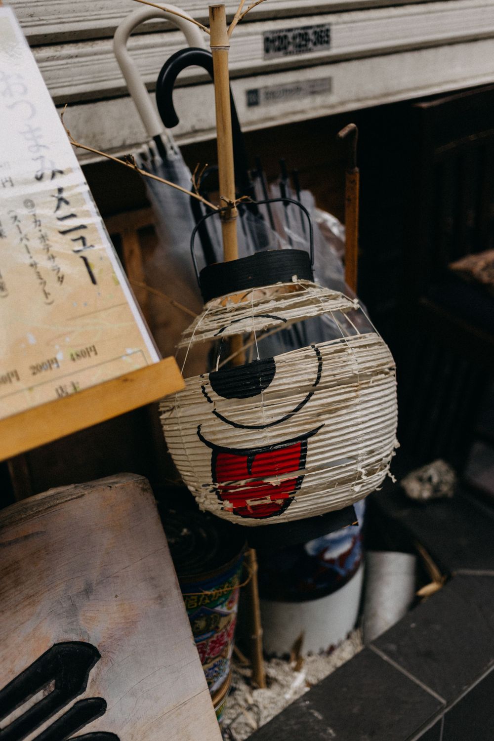 Traditional Japanese paper lantern with a painted smiling face design.