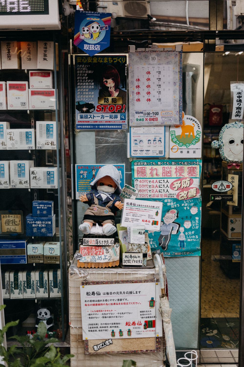 Storefront covered in Japanese advertisements, posters and colorful signage.