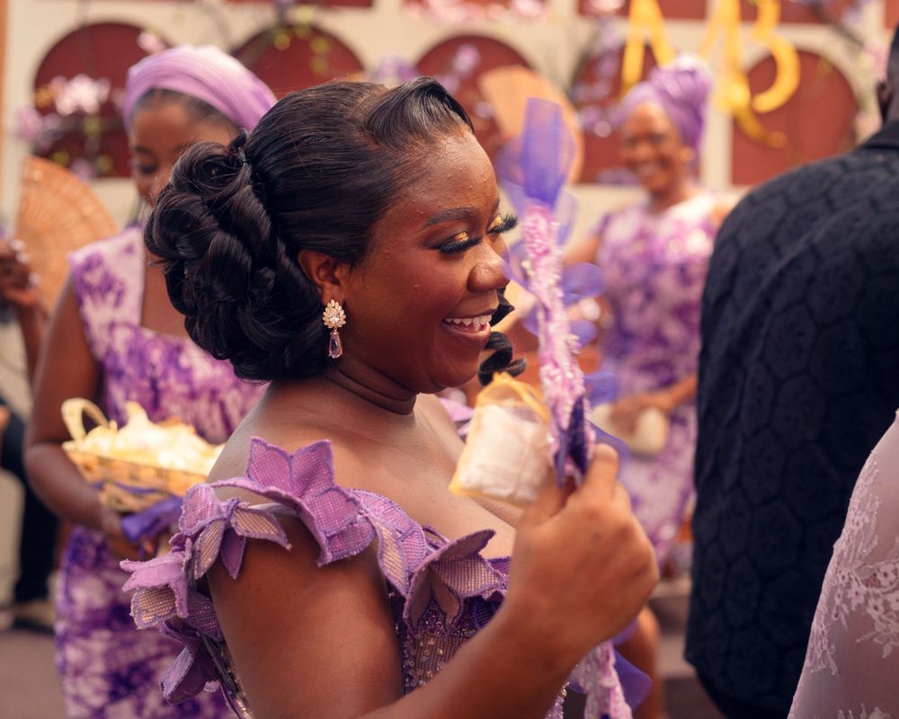 A guest in purple dress enjoys refreshments at a formal celebration.
