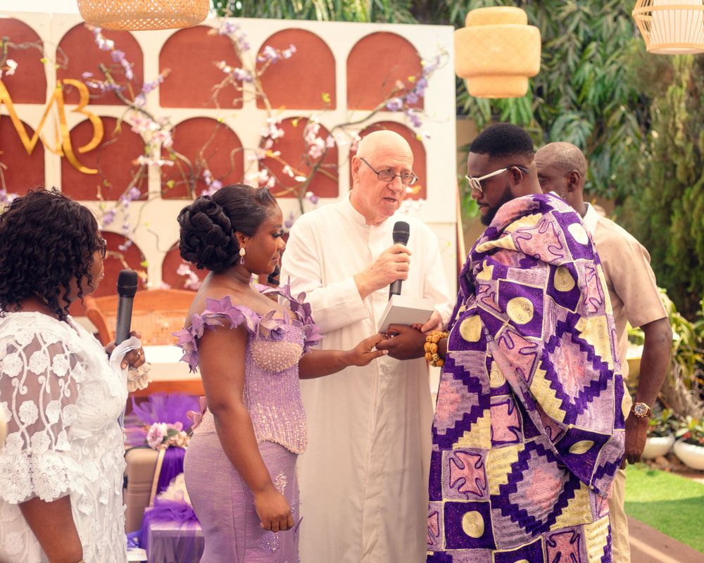 Wedding celebration featuring attendees in coordinated purple and white traditional formal attire.