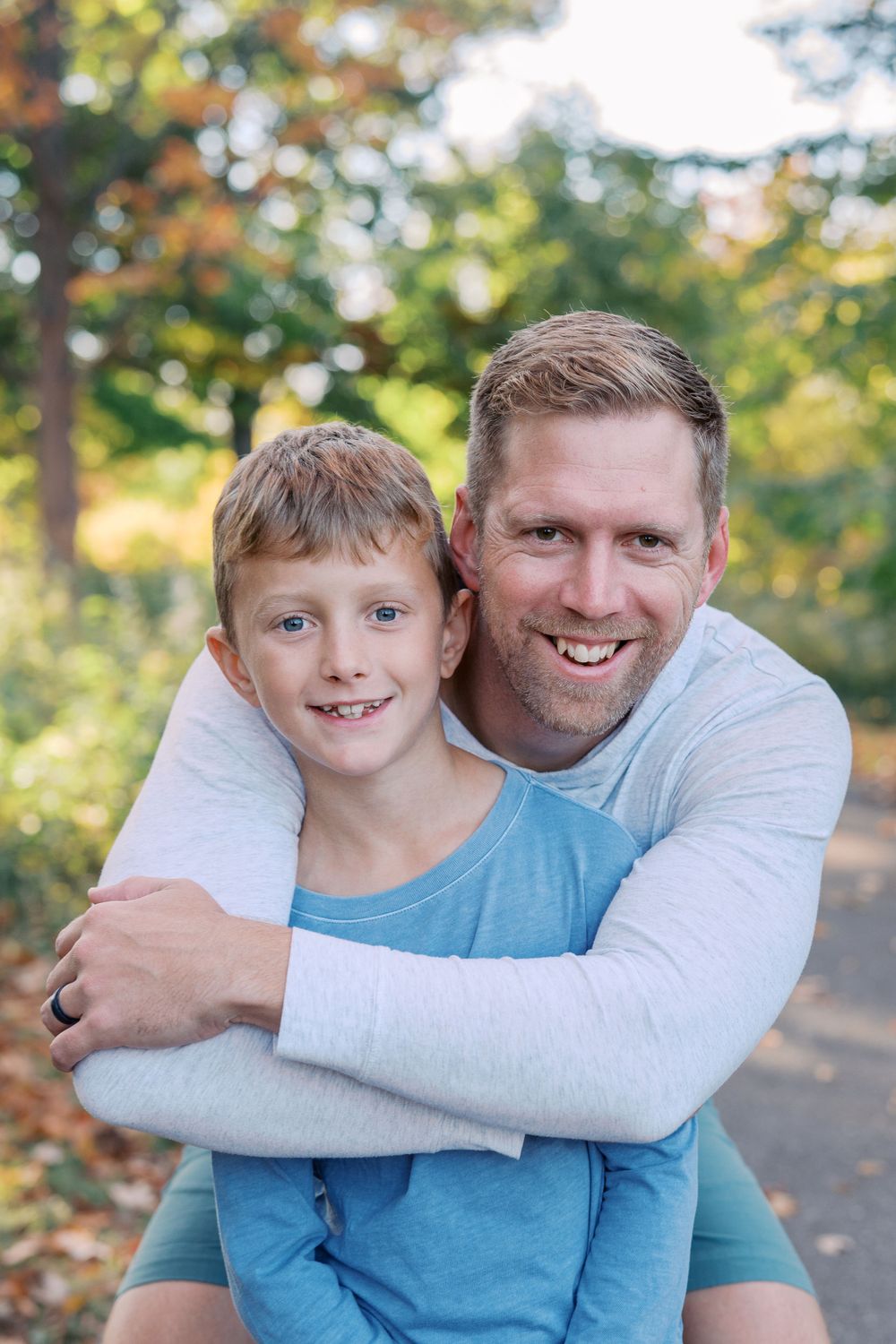 Heartwarming embrace between parent and child in matching blue outfits.