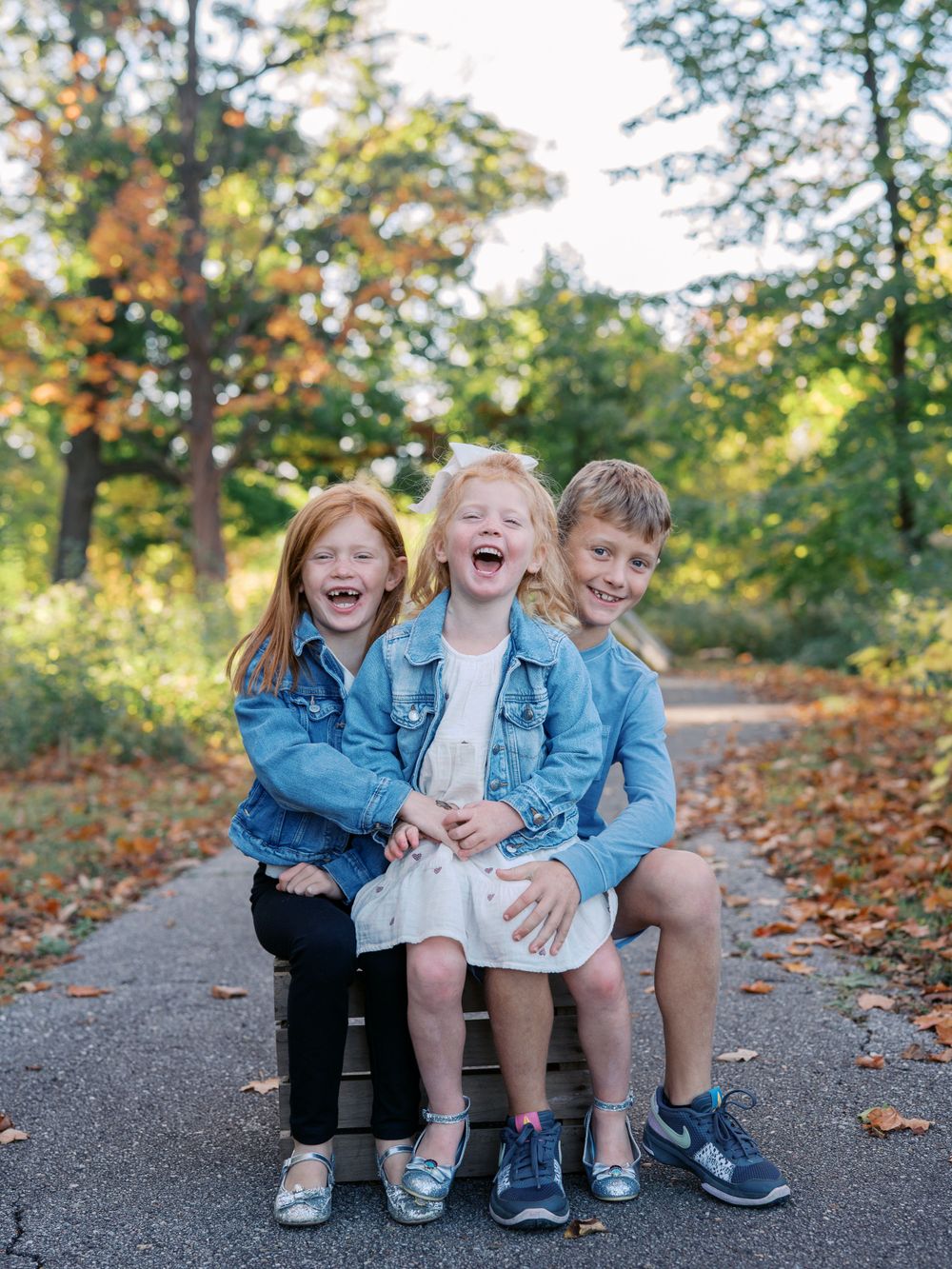 Candid moment of family laughter while sitting together on a forest path.