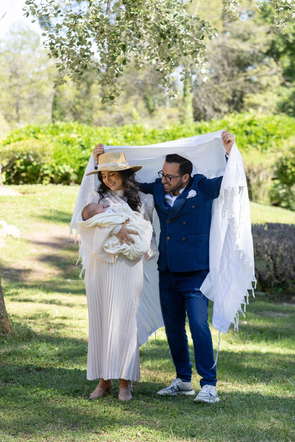 Deux parents célèbrent la Brit Mila de leur enfant avec tendresse, rempli d'amour et de complicité sous le tallit