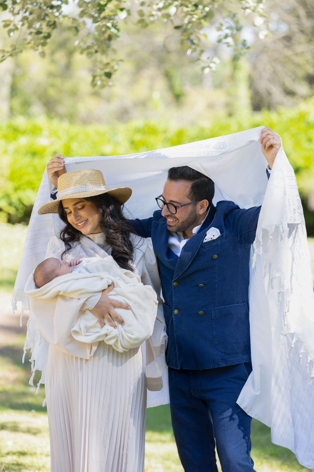 Deux parents célèbrent la Brit Mila de leur enfant avec tendresse, rempli d'amour et de complicité sous le tallit
