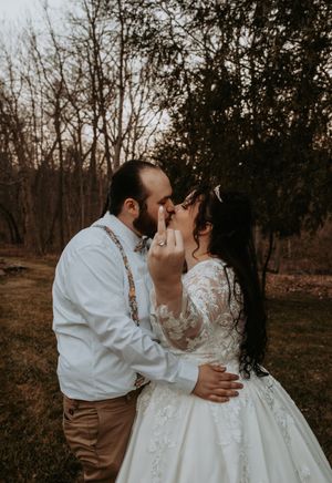 Romantic winter wedding moment in brown and white with lace details in wooded setting.