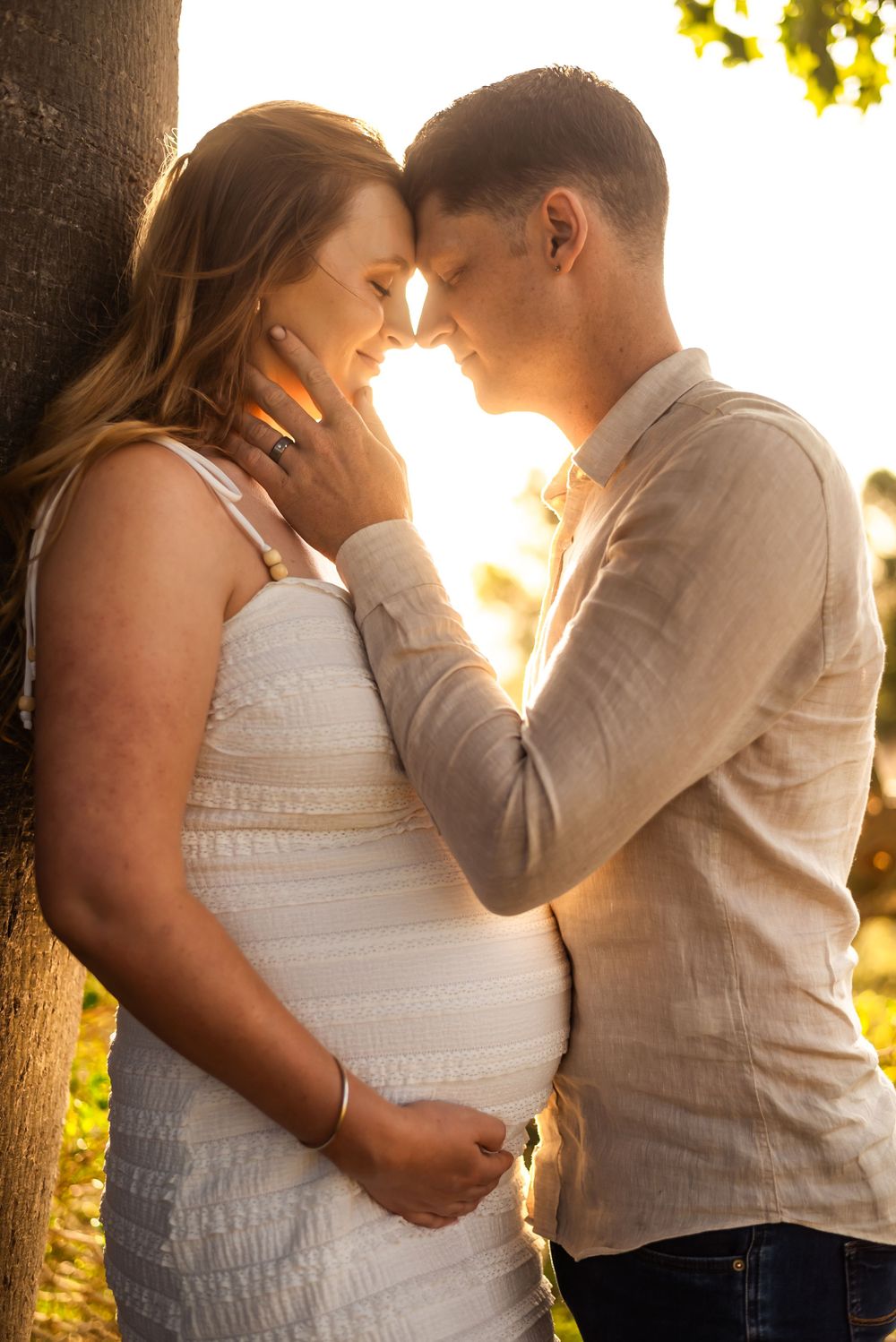 Sweet intimate moment captured during golden hour maternity session.