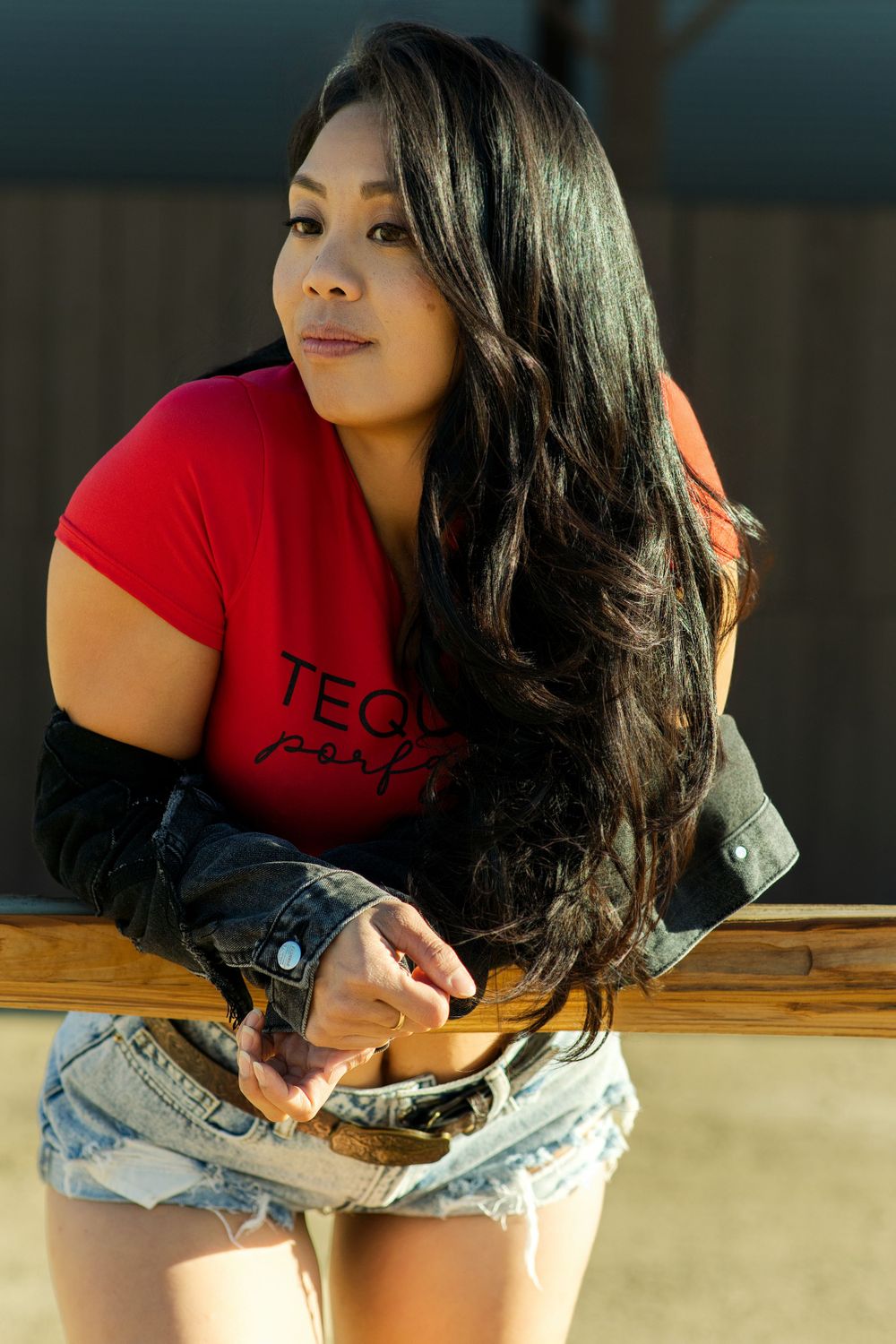 Casual outdoor portrait in red t-shirt and denim shorts.