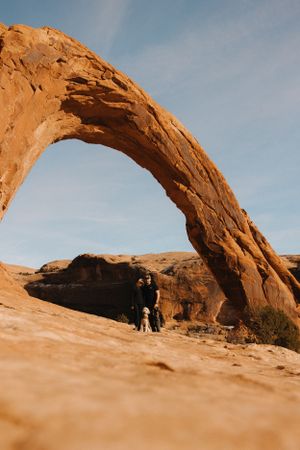 Natural sandstone arch formation in the desert with dramatic lighting and blue sky, Corona Arch.