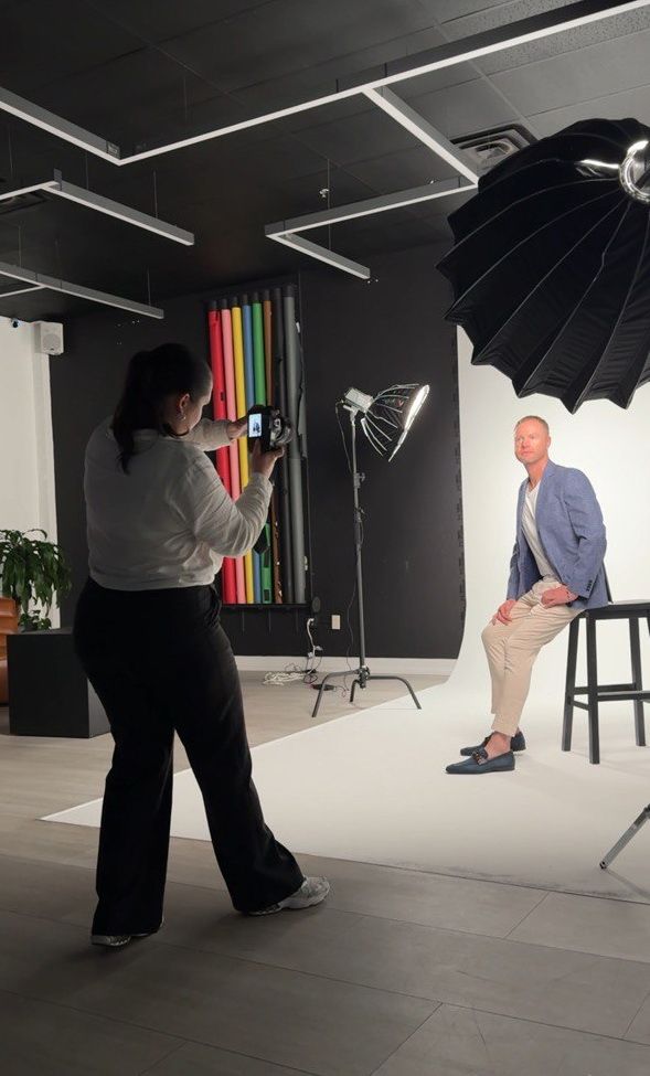 Photography session in a modern studio with lighting equipment and colorful wall accents.