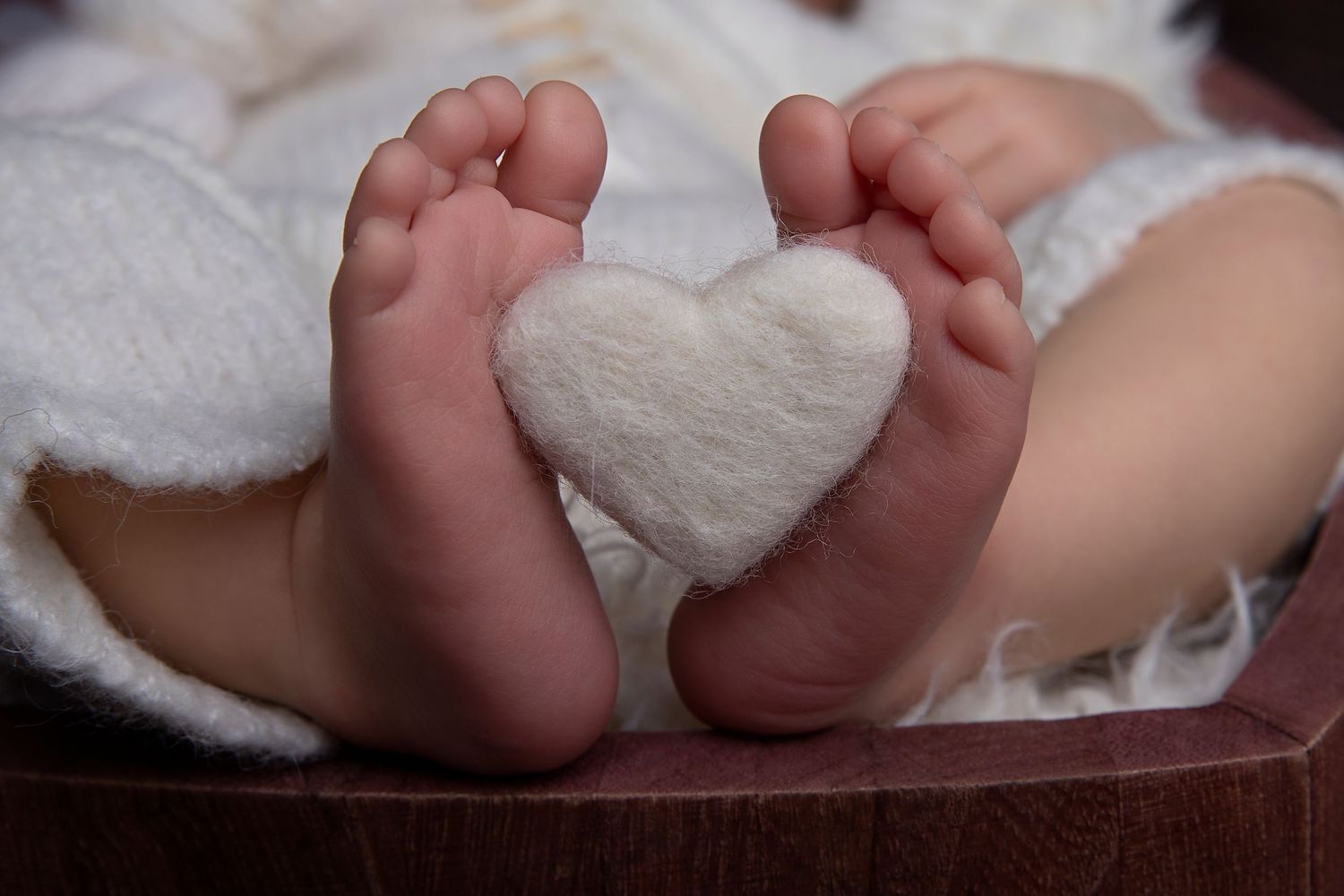 Black and white close-up photographs of baby feet arranged in a horizontal series showing different angles and poses.