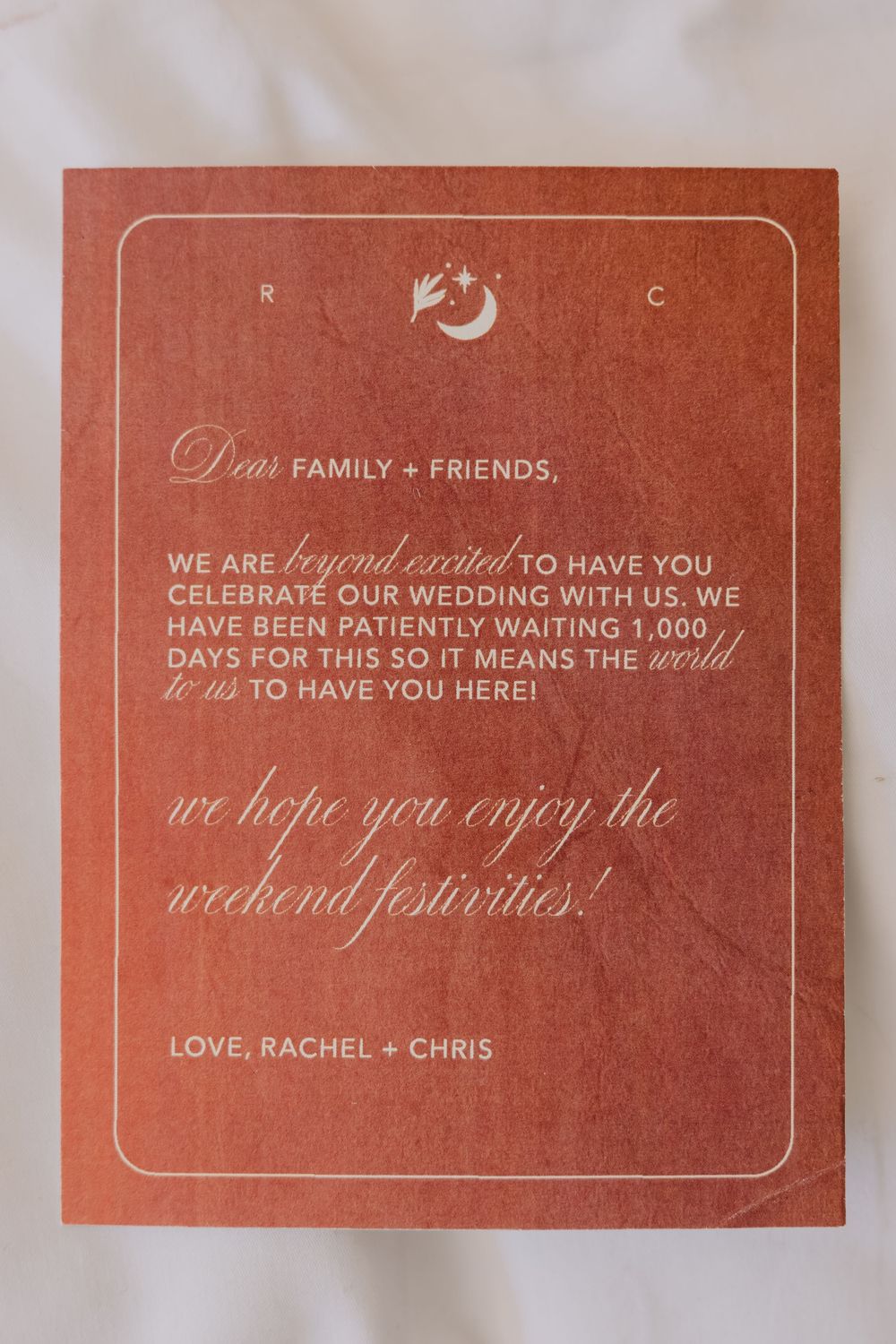Rustic terracotta wedding welcome card addressed to family and friends from Rachel and Chris.