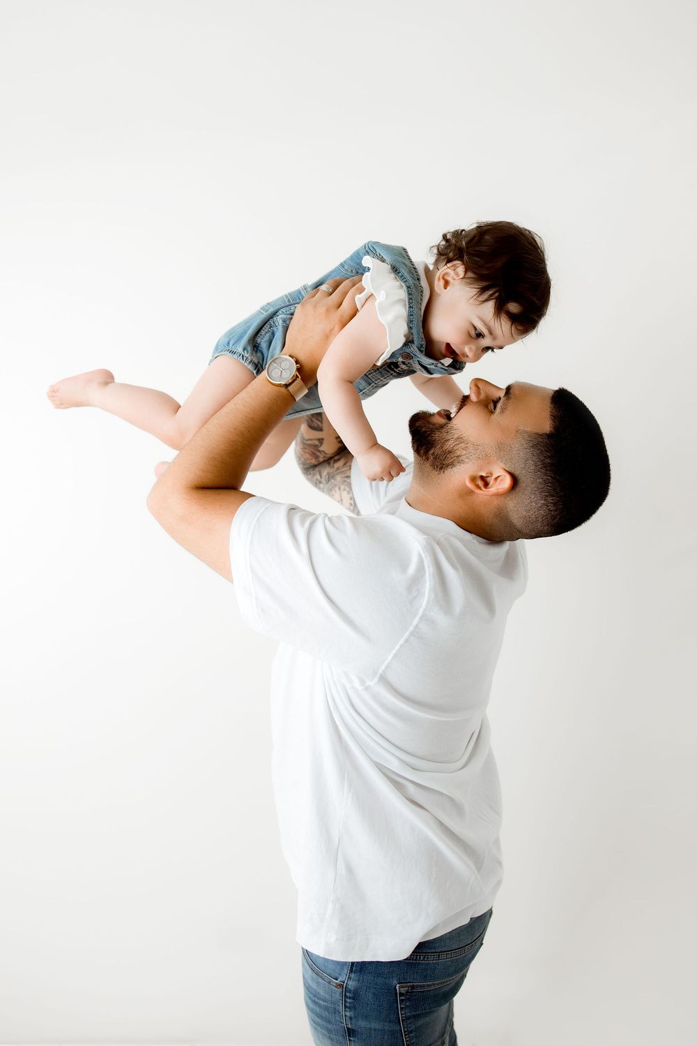 dad lifting the baby both laughing