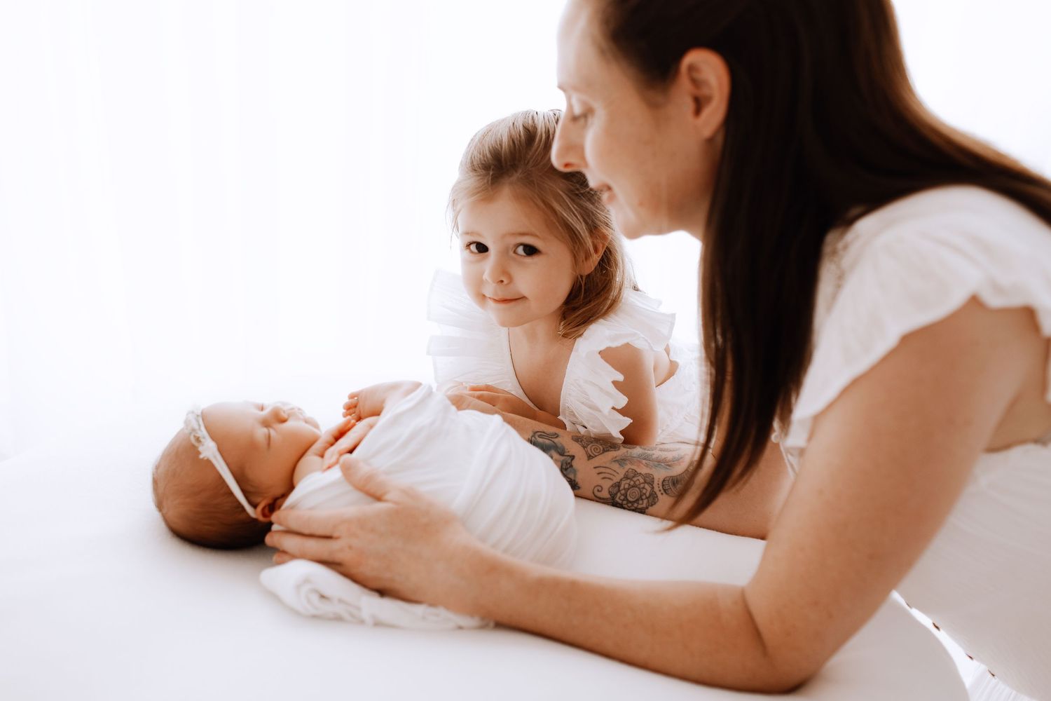 Natural lifestyle family photography series with baby in white studio setting.